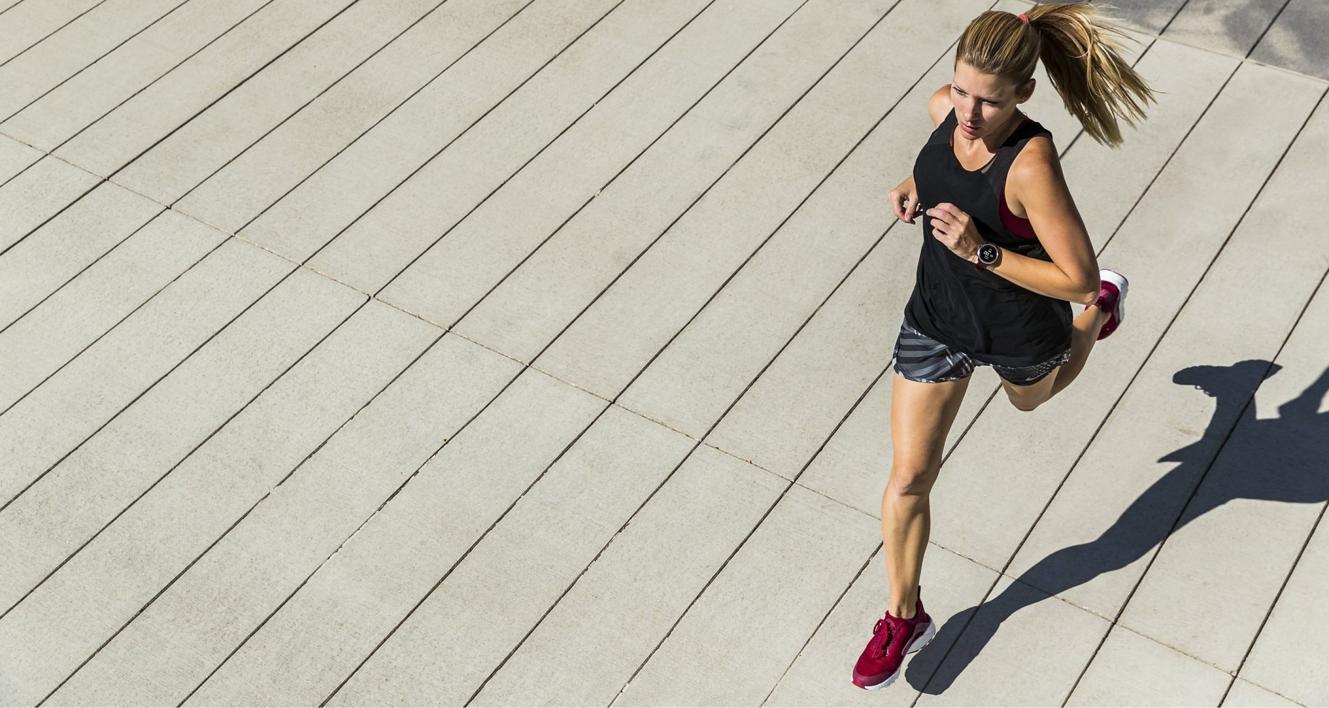 Runner in motion on an outdoor track, emphasizing speed and determination