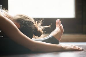 Person performing a deep stretch on a mat, highlighting flexibility and fitness